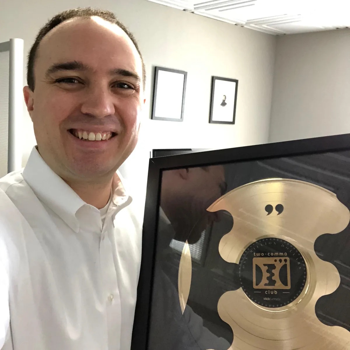 Jon Bator holding his 2 Comma Club award plaque